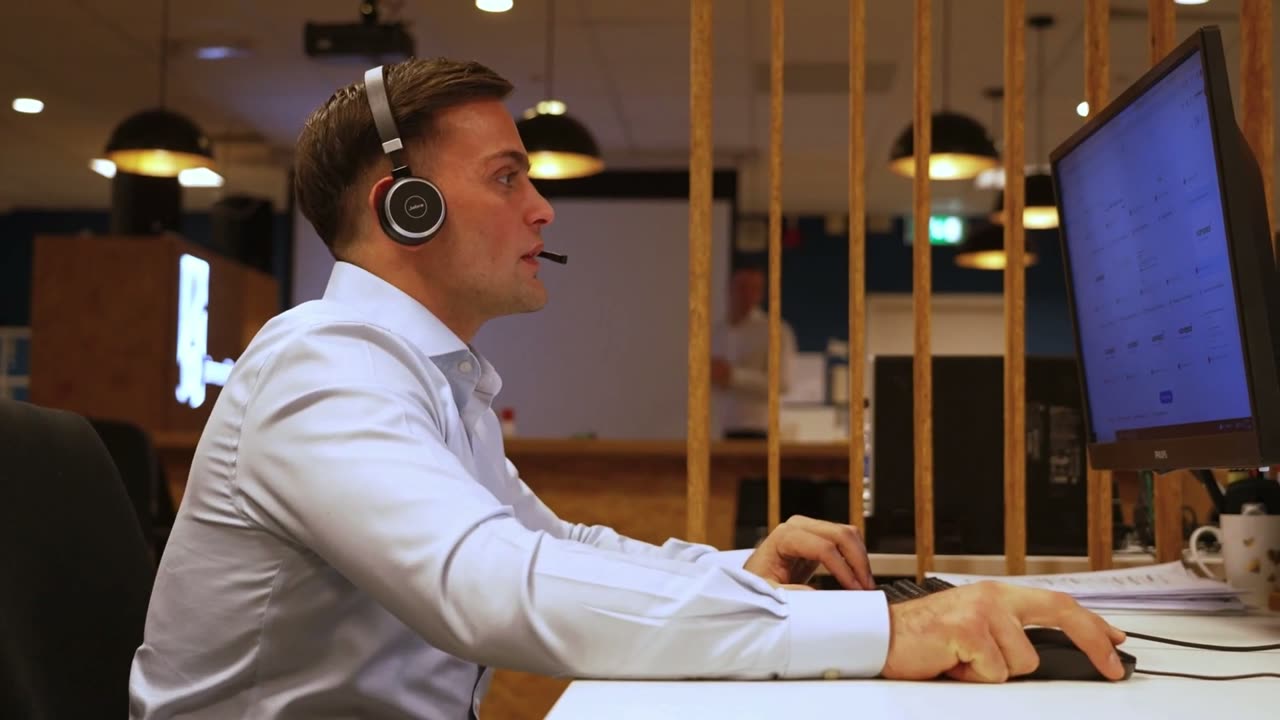 Een van onze bellers met headset aan het werk achter zijn scherm